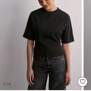 Svart T-shirt med knytning i ryggen - Det är jätte gullig svart T-shirt blus mens knytning i ryggen så att man kan kontrollera hur tajt den är, den är köpt för 249 kr från Nelly i storlek xs. Jag kan även mötas upp i Stockholm.inte mycket använd. Kontakta om nån har någon fråga❤️