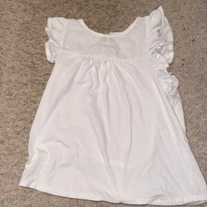 Vit blus - Den är en kort blus. Jag har klippt lappen på den som säger vilket tyg och hur man ska tvätta den. 