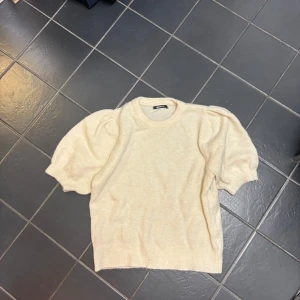 Supersöt topp - Säljer denna stickade kortärmade t-shirten med puffärmar i stl xs. Knappt använd så den är i toppenskick. Köpte från GinaTricot.