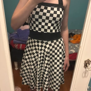 Rutig klänning  - En rutig klänning som inte har blivit använd och som man knyter där bak.