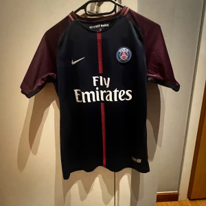 PSG Tröja - Äkta PSG tröja från säsongen 17/18. Tröjan är köpt från ClassicFootballShirts i somras, skick 9/10 i storlek L (barn).  PS: Trycket på ryggen är fel då Mbappé aldrig hade nr27 utan nr29. Men tröjan i sig är äkta!