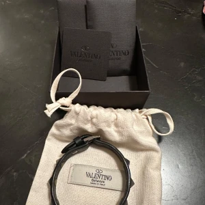 Valentino armband - Valentino armband med svarta nitar säljes. Superbra skick endast andvänt fåtal gången. Allt på bild följer med. Skriv för mer info och bilder!