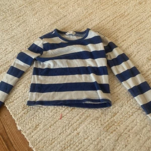 En vit och blårandig tröja - Jättefin nästan helt oanvänd.