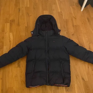 Tommy hilfiger puffer  - Säljer riktigt fet Tommy Hilfiger puffer jacka då jag tyvärr växt ur den. Jackans enda defekt är att den har behövt lagas på som man ser på bilderna, men det är däremot något som man knappt lägger märke till.Pris kan diskuteras vid snabb affär