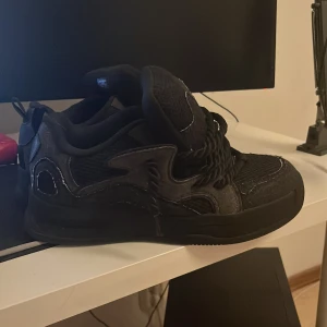 Svarta sneakers med grov snörning - Snygga svarta sneakers med en unik design och grov snörning. Skorna har en robust sula och detaljer i syntetmaterial som ger en cool look. Perfekta för en casual stil. Zara chunky skot storlek 44 helst för män och har zara påse till den. knappt använda 