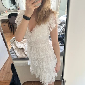 Studentklänning Bubbleroom - Säljer denna superfina studentklänningen från Bubbleroom med volanger🤍 Strl XS, nyskick men har sytt om den så den nu är V-ringad (modellen heter Lace Frill Short Dress). Klänningen har fina knappar i ryggen! Köpt för 899kr, säljer för 700kr+frakt! Skriv för fler bilder🤍Dragkedjan i ryggen fastande en gång när jag provade klänningen i den yttersta volangen där bak och gjorde därav ett litet veck/hål i volangtyget. Men detta är inget som syns alls då nästa volang bakom denna gör att det ”döljs”.