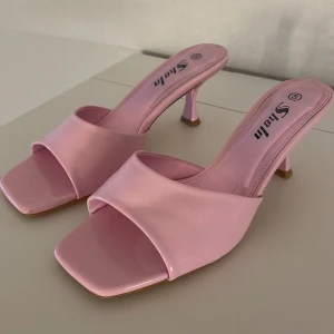 Rosa klackskor från Shein - Säljer ett par stiliga rosa klackskor från Shein. Skorna har en öppen design med fyrkantig tå och en elegant klack. Perfekta för att ge en färgklick till din outfit.