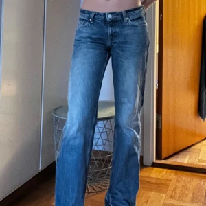 Blå jeans med bootcut - Snygga blå jeans med bootcut-stil och lowwaist. Har klippt upp en slits längst ner som man ser på andra bilden. 