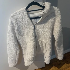 Vit teddyjacka med huva - Mysig vit teddyjacka i storlek 150. Jackan är från Lager157 och har både huva och dragkedja. Perfekt för kyliga dagar. Jackan har två praktiska fickor framtill och är långärmad. Den fluffiga texturen ger en varm och mysig insida och utsida. Tröjan ligger ute på mitt vinted konto, tilde.karlsson, också. 💕