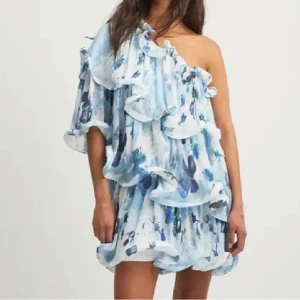 Blåmönstrad oneshoulder klänning - Snygg oneshoulder klänning med blått mönster och volangdetaljer. Perfekt för sommarens fester. Luftig och bekväm passform. Aldrig använd, lappen sitter kvar☺️