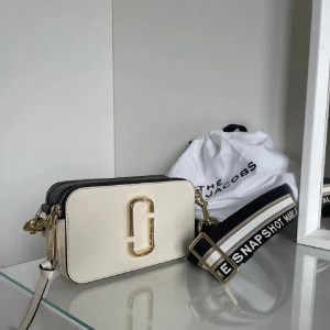 Marc Jacobs väska - Snygg axelväska från Marc Jacobs i vit och svart med guldiga detaljer. Nyskick