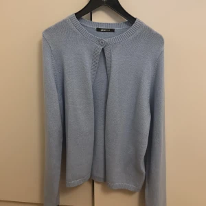 Ljusblå kofta från Gina tricot - Säljer en stilren ljusblå kofta från gina. Den har en enkel knapp framtill och är perfekt för lager-på-lager. Koftan är långärmad och tillverkad i ett mjukt material som ger en skön känsla. Passar utmärkt till både vardag och mer uppklädda tillfällen.