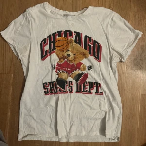 Vit t-shirt med björntryck från NewYorker - Säljer en vit t-shirt från NewYorker med ett coolt tryck av en björn som spelar basket. Perfekt för en avslappnad stil. 🐻🏀säljs då den inte kommer till användning