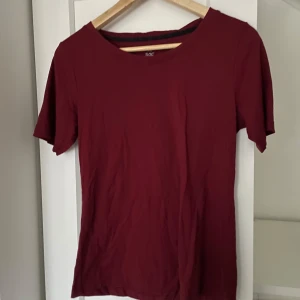 Vinröd tränings t-shirt från SOC - Säljer en basic vinröd träningst-shirt från SOC i storlek M. Den har en rund hals och är kortärmad Materialet är luftigt, mjukt och bekvämt 