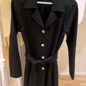 Busnel kofta  från Valentine - Elegant svart kappa från Valentine i ull. Kan även användas som klänning . Knälång  Passar XS -M stor i storleken . Använd vid några tillfällen den är som ny 