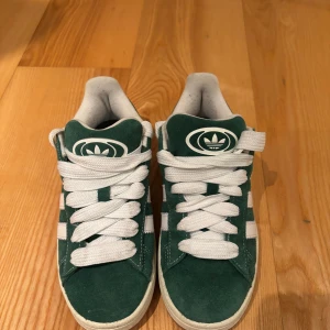 Gröna Adidas Campus sneakers - Snygga gröna Adidas Campus sneakers i mocka med vita detaljer och snörning. De har nu de vita snörena på men likadana gröna snören och tunnare gröna snören medföljer.