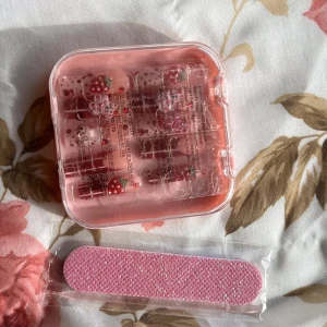 Nagelkit - Sött nagelkit med lösnaglar. Kommer i en praktisk rosa förvaringsask. Inkluderar en rosa nagelfil för enkel applicering och formning . Perfekt för speciella tillfällen.