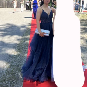 Balklänning - Elegant mörkblå balklänning med spetsdetaljer och tunna axelband. Klänningen har en v-ringad design och flera lager av tyll som ger en riktig prinsess känsla. Super bekväm och i jättefint skick. Nypris ligger på 3025 och den är i storlek 34 men skulle säga att den även passar 36 (jag har vanligtvis mellan 34-36)✨