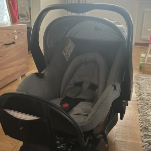 Grå bilbarnstol från Britax Römer - Säljer en grå bilbarnstol från Britax Römer. Det är designat för barn mellan 0-13 kg och har en bekväm vadderad insida. Perfekt för att hålla din bebis säker och bekväm under bilresor. Stolen har ett justerbar bärhandtag och är lätt att montera i bilen. Enbart använd till ett barn tills hon var ett år sen bytte vi stol till henne. Finns någon fläck på något ställe men stolen är i fint skick. Finns att hämta i Karlskrona (skickas inte)