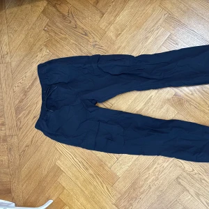 Svarta träningsbyxor från SOC - Svarta träningsbyxor från SOC i storlek L. Byxorna har en elastisk midja med snörning för justerbar passform. Perfekta för träning eller avslappnade dagar.