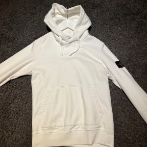 Stone Island Hoodie - Vit fin Stone Island hoodie, herr storlek S. På sida 3 så ser du en defekt, defekten är väldigt liten så man tänker knappt på att den finns. Använd men fortfarande i fint skick. Kommer från hem med djur😇 Priset går att diskuteras💗