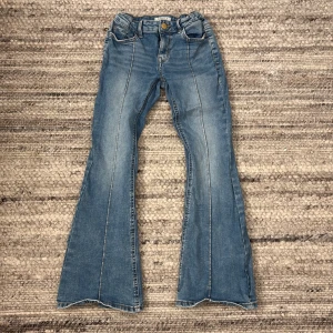 Blå bootcut jeans från Lindex - Säljer ett par snygga blå bootcut jeans från Lindex. Är i storlek 140 och väldigt bekväma. Pris kan även diskuteras om man är intresserad. Perfekta för en avslappnad stil. Passar barn i åldern 9-10 år🌺