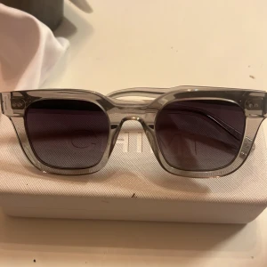 Solglasögon från CHIMI - (Pris kan diskuteras) Snygga solglasögon från CHIMI med transparent båge och mörka linser. Perfekta för att ge en stilren touch till din look. Kommer i ett elegant fodral.säljer dem eftersom att dem aldrig kommit till användning🥰