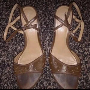 Väldigt snygga damskor nya storlek 39 - Snygga bruna sandaler med dekorativa detaljer och smala remmar som korsas över foten. Perfekta för varma dagar och ger en elegant touch till din outfit.