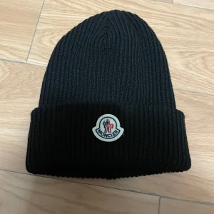 Svart ribbad mössa från Moncler - Riktigt fet moncler mössa i nyskick. Riktigt skönt och behagligt material. Köptes av en kompis. Pris kan diskuteras
