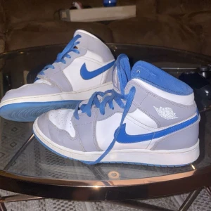 Jordan 1 blå vit. Vill bara bli av med dem, måste köpa snus fort  - Snygga Nike Air Jordans i blått och vitt med klassisk snörning. Skorna har en stilren design med blå detaljer och vit bas. Perfekta för dig som vill ha en sportig look.