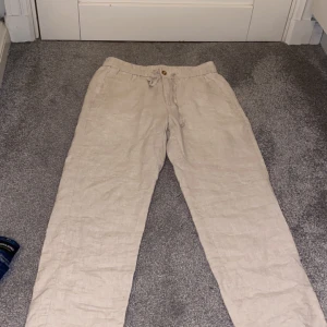 Beige linnebyxor från Skagen clothing - Snygga beige linnebyxor i 100% linne från Skagen i storlek S. Linne byxorna är använda Max 1-2 gånger därför är dem i perfekt skick. Redkomenderas för längd 160-170. Ny pris runt 950 kr