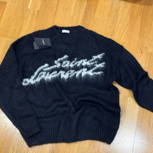Saint Laurent Tröja - Stickad Saint Laurent tröja, storlek S, några lösa trådar men går att ta bort med klädvårdsrulle👍Annars helt ny, oanvänd och inte äkta!