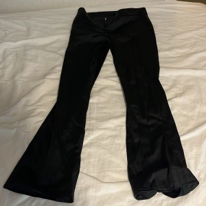 Svarta byxor från Lindex storlek S - Snygga svarta byxor från Lindex med en elegant bootcut-stil. Perfekta för att ge en stilren look. Byxorna har en slät yta och är tillverkade i ett bekvämt material som ger en fin passform.