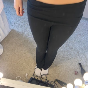 Svarta byxor från Gina Tricot - Snygga svarta byxor från Gina Tricot med hög midja och bootcut-stil. Perfekta för en stilren look. Tillverkade i ett mjukt och bekvämt material.Däremot är det ett hål på knät men det går och sy ihop🩷