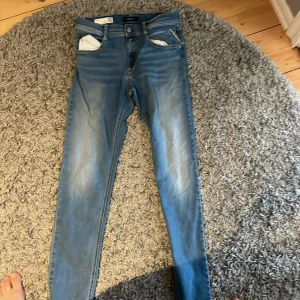 Blå jeans från Replay - Snygga blå jeans från Replay med en klassisk femficksdesign och dragkedja. De har en slim passform och är perfekta för en stilren look. Märket Replay syns på den lilla fickan. Nypris 1500