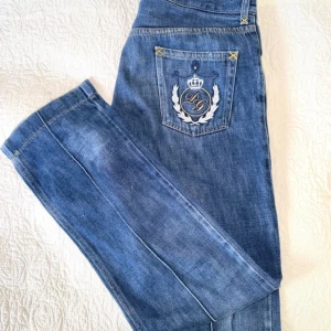 Blå D&G  jeans med broderad detalj - Säljer ett par snygga vintage blå D&G jeans med en cool broderad detalj på bakfickan. Vet ej om de är äkta men de är köpta i en vintage märkes butik i italien:)