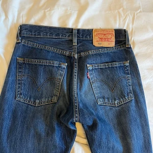 Levi's 501 jeans - Säljer ett par klassiska Levi's 501 jeans i mörkblå denim. De är i bra skick och har en straight passform med knappgylf. Perfekta för både vardag och fest! Passar till allt och är superbekväma.