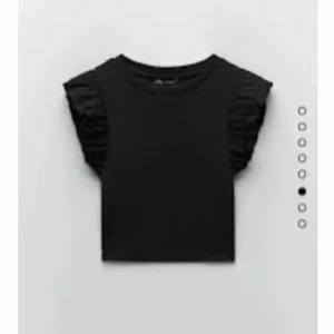 Svart topp med volangärmar från Zara - Säljer en snygg svart topp från Zara i storlek M. Den har jätte fina volangdetaljer på ärmarna. Perfekt för både vardag och fest! Inga defekter.