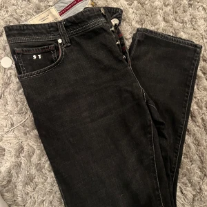 Tramarossa jeans - Säljer ett par snygga svarta jeans i mycket bra skick. De är tillverkade i Italien och har en klassisk slim passform. Jeansen är använda ett fåtal gånger och är perfekta för fest. De är små i storlekarna i alla fall på bredden så du som har 34-36 i vanliga fall passar perfekt i dessa! Kostar 5000 kr nya.
