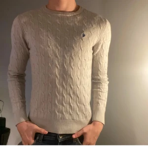 Beige stickad tröja med kabelmönster - Säljer en snygg beige Morris tröja. Den e stickad och den sitter som XS, perfekt för höst och vinter. Tröjan är i mycket bra skick. 