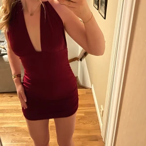 Vinröd klänning - Säljer denna supersnygga vinröda klänning med halterneck-design❤️Den kan knytas på olika sätt (bild 1 & 2). Den är aldrig använd och i nyskick. Köpt för 300, säljer för 120. Skriv för frågor! 