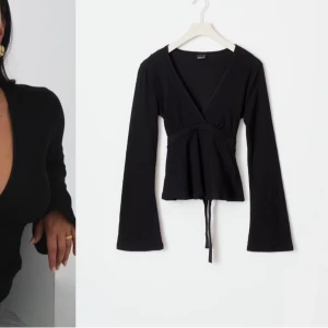 Svart tie top från gina❤️ - Snygg svart omlottopp från Gina i mjukt material. Den har långa ärmar och en knytning i ryggen som ger en fin passform. Perfekt för både vardag och fest! 🖤
