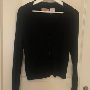 Ribbad svart tröja  - Svart ribbad tröja med knappar från h&m, använd fåtal gånger är som ny