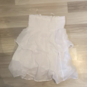 Vit klänning från Gina Tricot - Söt vit klänning från Gina Tricot i storlek 146/152. Den har en smockad överdel och volangdetaljer som ger en luftig och somrig känsla. Perfekt för varma dagar eller sommarfester! 💕