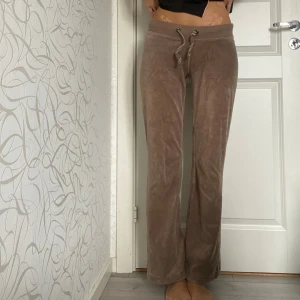 Lågmidjade beige mjukisbyxor - Supermysiga beige mjukisbyxor i sammet med snörning i midjan. Perfekta för en chill dag hemma eller en avslappnad promenad. De är lågmidjade.Materialet är mjukt och skönt mot huden.