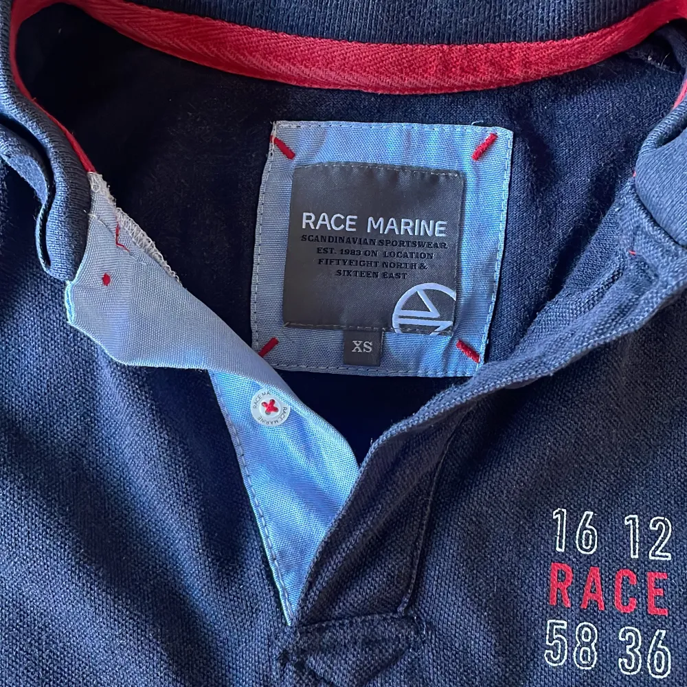 Säljer en snygg mörkblå pikétröja från Race Marine i storlek XS. Den har röda och vita ränder över bröstet och broderad text på framsidan. Tröjan är kortärmad och perfekt för en avslappnad stil. Passar både till vardags och lite finare tillfällen. 🏄♂️Pris kan alltid förhandlas!. T-paidat.