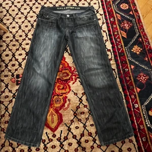 Grå jeans från Splinter - Säljer ett par grå jeans från Splinter i bra skick. De har en klassisk straight passform och är tillverkade av 60% bomull och 40% polyester. Perfekta för både vardag och fest! 🖤