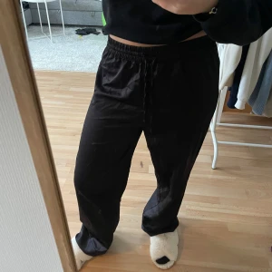 Svarta pyjamasbyxor - Säljer ett par svarta satin pyjamasbyxor i loose fit. De är superbekväma med resår och snörning i midjan. Köpt på Gina Tricot i storlek S. Använt fåtal gånger💗