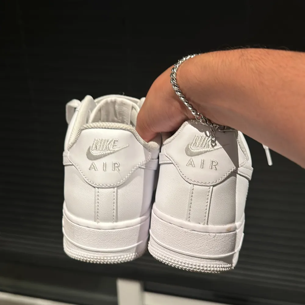 Säljer ett par klassiska vita Nike Air Force sneakers i mycket bra skick. De har en stilren design med snörning och är perfekta för vardagsbruk. Sulan är i gott skick med minimal slitage. Perfekta för både vår och sommar! Storlek 43. Skor.