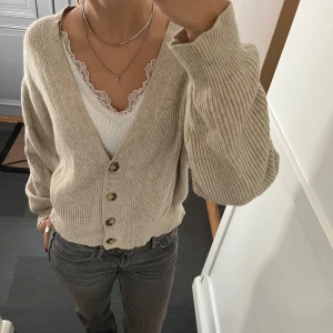 Beige stickad kofta  - Beige stickad kofta från Bikbok i storlek M, skulle säga att den även passar S. Fit skick. Använd gärna köp nu!